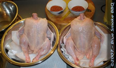 Foto van twee kippen die zitten te drogen na twee keer wassen in water met azijn ter voorbereiding van het grillen in de oven of barbecue.
