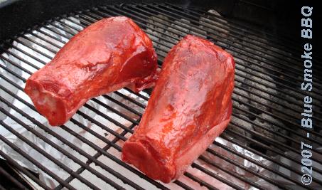 Foto van in Char Siew gemarineerde Chinese varkenshielen op het barbecue rooster.